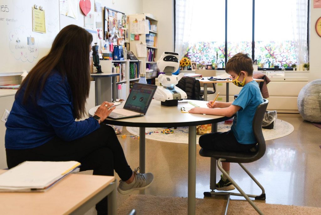 teacher and student working with Misty robot