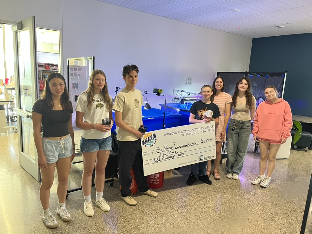 Students hold a large check for $1,000 awarded for a project on community resilience to natural disasters.